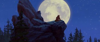 Movie still from “Brother Bear” (2003), directed by Robert Walker – A bear sitting on top of a rock in front of the moon; Wide shot, Low angle