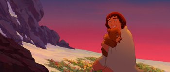 Movie still from “Brother Bear” (2003), directed by Robert Walker – A woman holding a teddy bear while standing next to a bear; Wide shot, Low angle