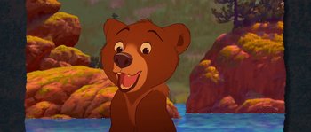 Movie still from “Brother Bear” (2003), directed by Robert Walker – A cartoon of a brown bear smiling at the camera; Medium shot, Low angle