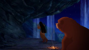 Movie still from “Brother Bear 2” (2006), directed by Ben Gluck – A woman and a bear in a cave with a waterfall in the background; Wide shot, Over the shoulder angle