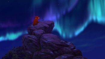 Movie still from “Brother Bear 2” (2006), directed by Ben Gluck – A bear sitting on top of a rock looking at the sky; Extreme Wide shot, Low angle