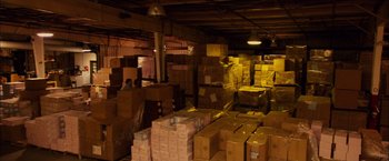 Movie still from “Bubble” (2005), directed by Steven Soderbergh – A warehouse filled with lots of cardboard boxes; Extreme Wide shot, High angle