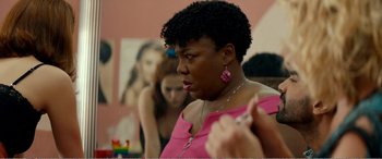 Movie still from “Buffaloed” (2019), directed by Tanya Wexler – A woman in a pink shirt is talking to another woman; Close Up shot, Over the shoulder angle