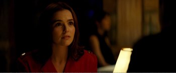 A woman sitting in front of a table with a lamp