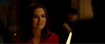 A woman in a red jacket smiles at the camera