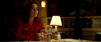 A woman sitting in front of a lamp at a table