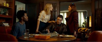 A man sitting at a dinner table with two women
