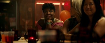 A woman sitting at a table in front of balloons