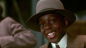 A young man wearing a hat and a suit