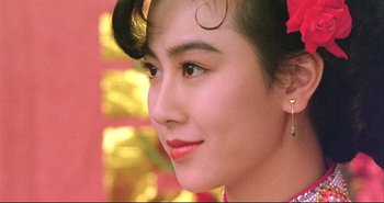 Movie still from “Bullet in the Head” (1990), directed by John Woo – A woman's face in front of a yellow background; Close Up shot, Low angle