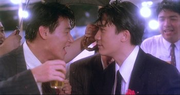 Movie still from “Bullet in the Head” (1990), directed by John Woo – Two men in suits and ties one is holding an umbrella; Close Up shot, Over the shoulder angle