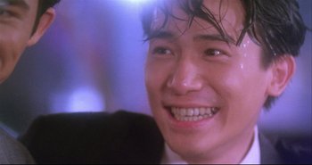 Movie still from “Bullet in the Head” (1990), directed by John Woo – A person with a smile on his face; Close Up shot, Low angle