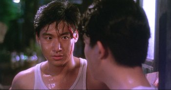 Movie still from “Bullet in the Head” (1990), directed by John Woo – A man looking at himself in the mirror in front of a mirror; Close Up shot, Over the shoulder angle