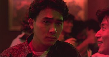 Movie still from “Bullet in the Head” (1990), directed by John Woo – A young man in a dark room with red lighting; Close Up shot, Low angle