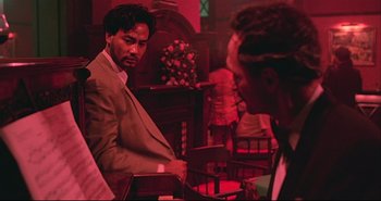 Movie still from “Bullet in the Head” (1990), directed by John Woo – A man in a suit and tie talking to another man in a suit and tie; Medium shot, Over the shoulder angle