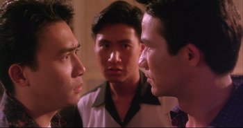Movie still from “Bullet in the Head” (1990), directed by John Woo – A group of men standing next to each other in front of a mirror; Close Up shot, Over the shoulder angle