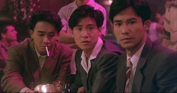 Movie still from “Bullet in the Head” (1990), directed by John Woo – A group of men sitting next to each other at a table; Close Up shot, High angle