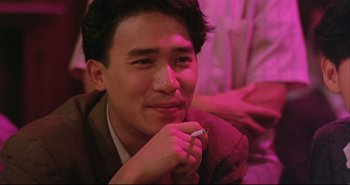 Movie still from “Bullet in the Head” (1990), directed by John Woo – A man with a cigarette in his mouth; Close Up shot, Over the shoulder angle