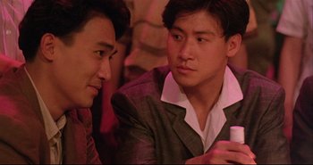 Movie still from “Bullet in the Head” (1990), directed by John Woo – Two young men are talking and drinking coffee; Close Up shot, Over the shoulder angle