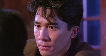 Movie still from “Bullet in the Head” (1990), directed by John Woo – A person wearing a jacket; Close Up shot, Over the shoulder angle