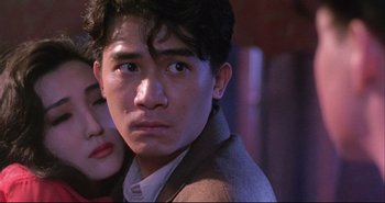 Movie still from “Bullet in the Head” (1990), directed by John Woo – A man and a woman looking at the camera; Close Up shot, Low angle