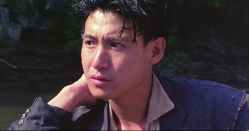 Movie still from “Bullet in the Head” (1990), directed by John Woo – A young man with black hair is looking into the distance; Close Up shot, Low angle