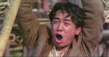 Movie still from “Bullet in the Head” (1990), directed by John Woo – An asian man with his mouth wide open; Close Up shot, Low angle