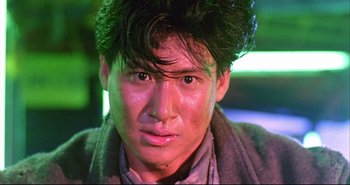 Movie still from “Bullet in the Head” (1990), directed by John Woo – A person wearing a jacket; Close Up shot, Low angle