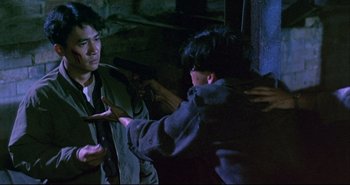 Movie still from “Bullet in the Head” (1990), directed by John Woo – Two men are fighting in a dark room; Medium shot, Over the shoulder angle