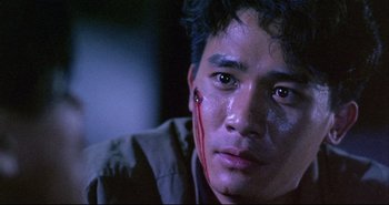Movie still from “Bullet in the Head” (1990), directed by John Woo – A person with blood on his face; Close Up shot, Low angle