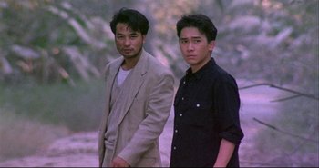Movie still from “Bullet in the Head” (1990), directed by John Woo – Two men standing next to each other in a park; Medium shot, High angle