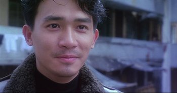 Movie still from “Bullet in the Head” (1990), directed by John Woo – A man's face in a black shirt; Close Up shot, Over the shoulder angle