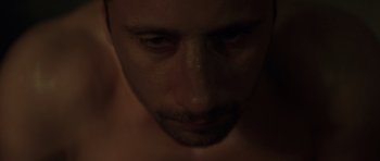 Movie still from “Bullhead” (2011), directed by Michaël R. Roskam – A man's face in the dark; Extreme Close Up shot, High angle