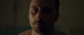 Movie still from “Bullhead” (2011), directed by Michaël R. Roskam – A man's face in a dark room; Close Up shot, Low angle