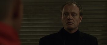 Movie still from “Bullhead” (2011), directed by Michaël R. Roskam – A person wearing a suit and tie; Close Up shot, Low angle