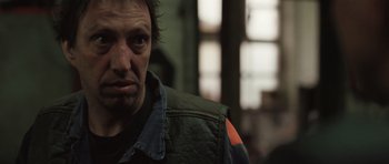 Movie still from “Bullhead” (2011), directed by Michaël R. Roskam – A person wearing a jacket; Close Up shot, Over the shoulder angle