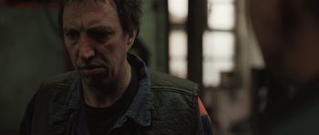 Movie still from “Bullhead” (2011), directed by Michaël R. Roskam – A person wearing a leather jacket; Close Up shot, Low angle