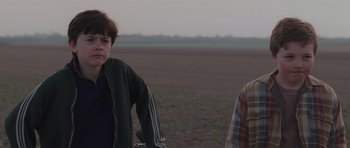 Movie still from “Bullhead” (2011), directed by Michaël R. Roskam – Two young people standing in a field near one another; Medium shot, Over the shoulder angle
