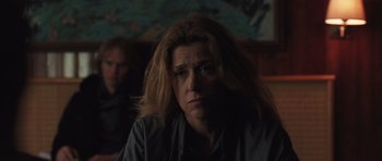 Movie still from “Bullhead” (2011), directed by Michaël R. Roskam – A woman sitting in front of a man in a dark room; Close Up shot, Low angle