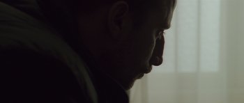 Movie still from “Bullhead” (2011), directed by Michaël R. Roskam – A man's face in the dark; Extreme Close Up shot, Low angle