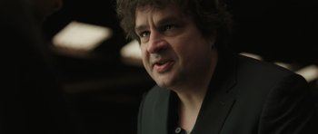 Movie still from “Bullhead” (2011), directed by Michaël R. Roskam – A person wearing a suit; Close Up shot, Over the shoulder angle