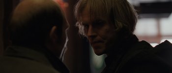 Movie still from “Bullhead” (2011), directed by Michaël R. Roskam – A man with blonde long hair is looking at a man with blonde long hair; Close Up shot, Over the shoulder angle