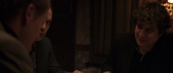 Movie still from “Bullhead” (2011), directed by Michaël R. Roskam – Two people sitting at a table with a glass of wine; Close Up shot, Over the shoulder angle