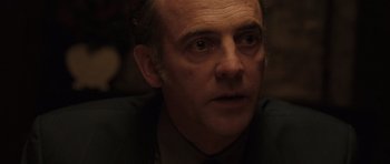 Movie still from “Bullhead” (2011), directed by Michaël R. Roskam – A person wearing a suit and tie; Close Up shot, Over the shoulder angle