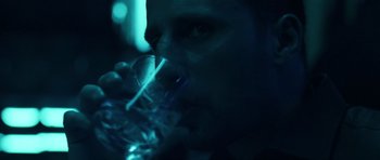 Movie still from “Bullhead” (2011), directed by Michaël R. Roskam – A man drinking a glass of water in a dark room; Close Up shot, Over the shoulder angle