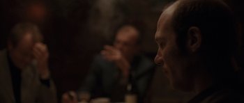 Movie still from “Bullhead” (2011), directed by Michaël R. Roskam – Two men sitting at a table in front of each other; Close Up shot, Over the shoulder angle