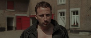 Movie still from “Bullhead” (2011), directed by Michaël R. Roskam – A person wearing a jacket; Close Up shot, Over the shoulder angle