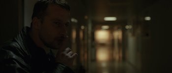 Movie still from “Bullhead” (2011), directed by Michaël R. Roskam – A person in a room with lights on; Close Up shot, Over the shoulder angle