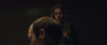 Movie still from “Bullhead” (2011), directed by Michaël R. Roskam – A woman standing next to a man in a room; Close Up shot, Over the shoulder angle