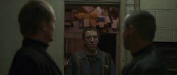 Movie still from “Bullhead” (2011), directed by Michaël R. Roskam – A man standing in front of a mirror in a room; Medium shot, Over the shoulder angle
